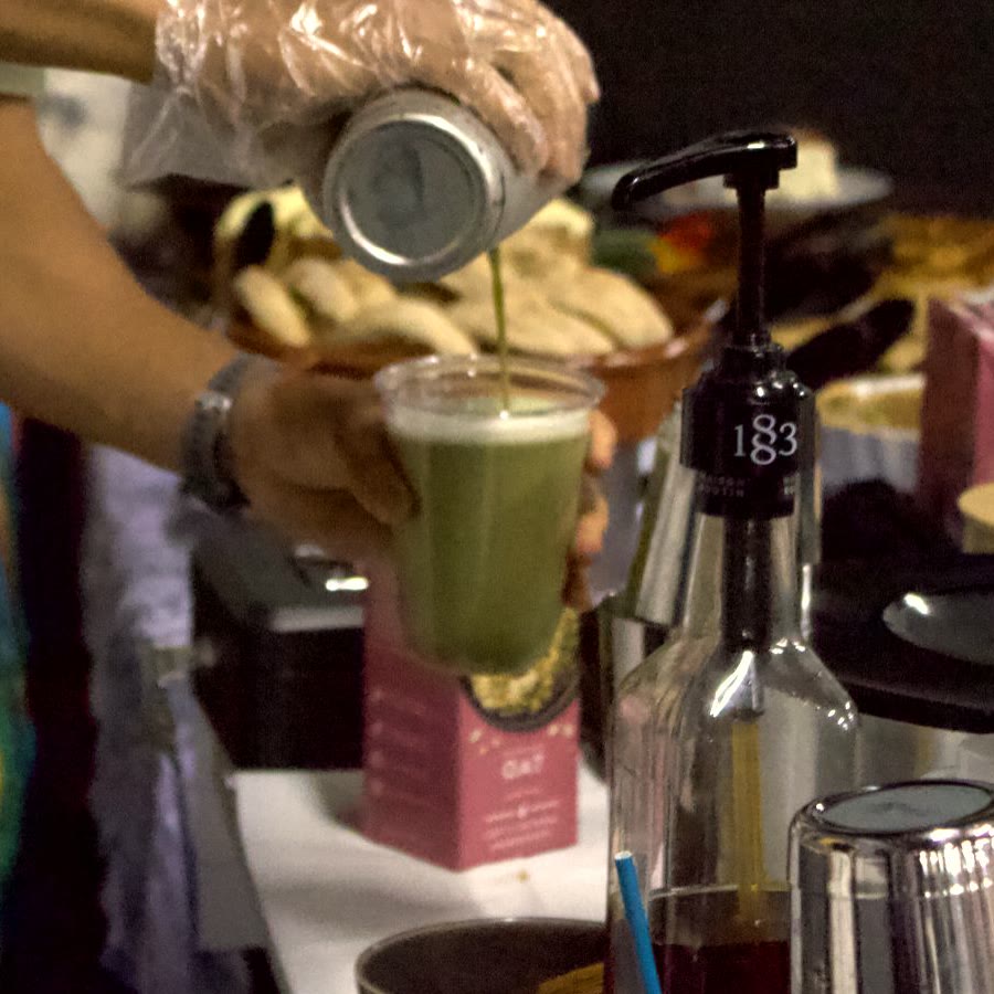 A green matcha being poured into a clear cup at the Sanabode table