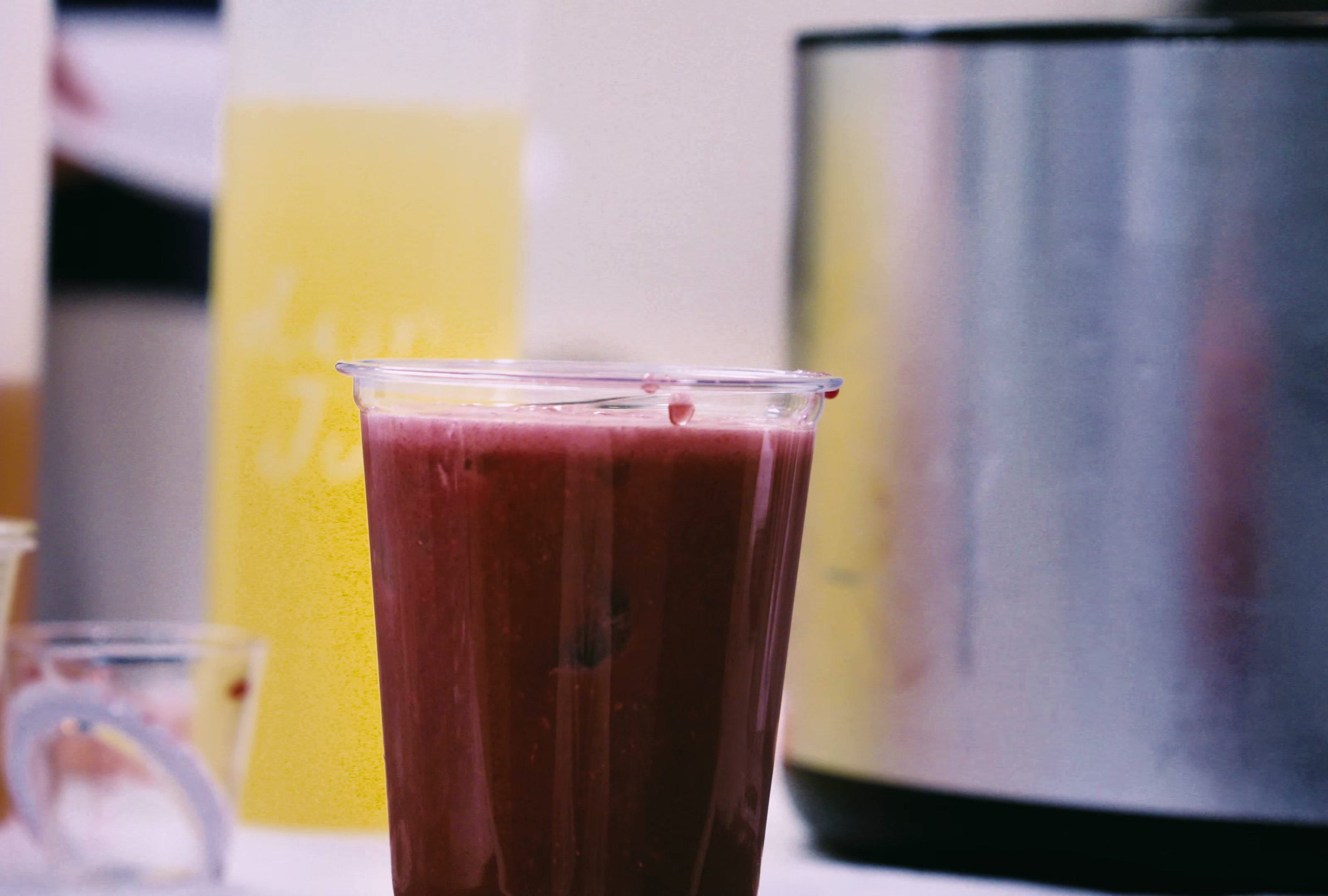 A deep red fruit blend in a clear cup at the Sanabode table, close up